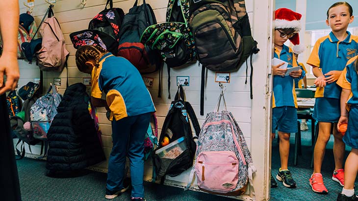 Young gir checking her backpack.