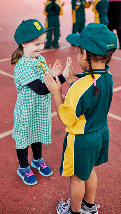 Two students playing together on the school playground.