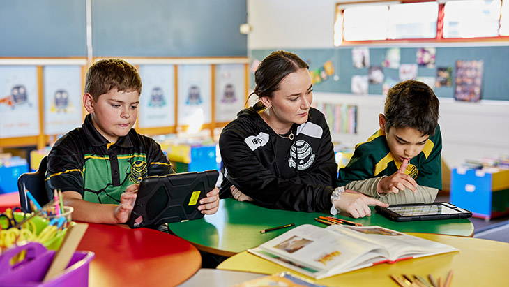 Students working in the classroom with a teacher.