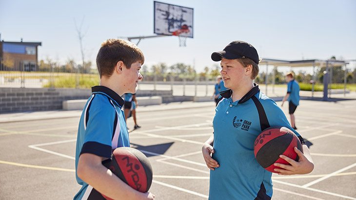 Two students playing basketball together.