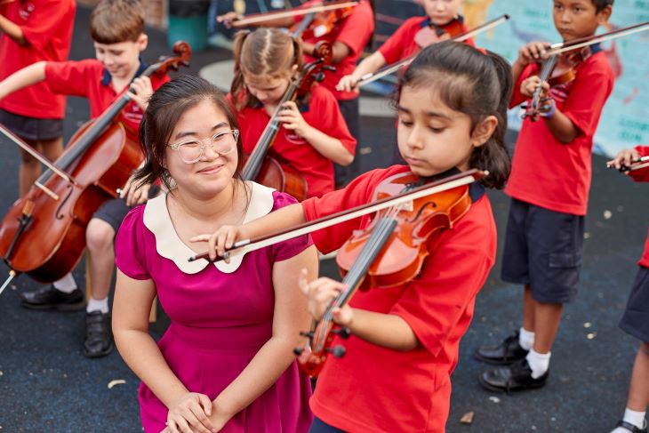 Music teacher watching student.