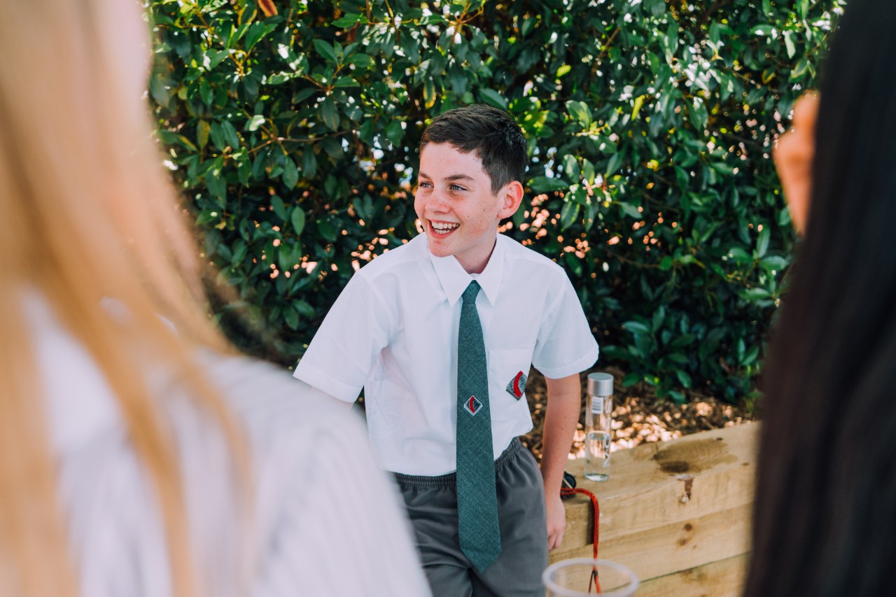 Student in the courtyard with classmates.