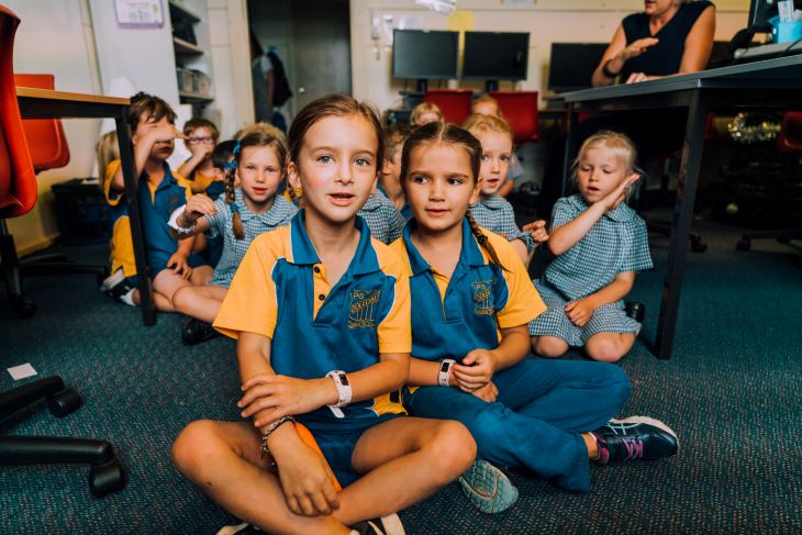 A group of students sitting on the floor.